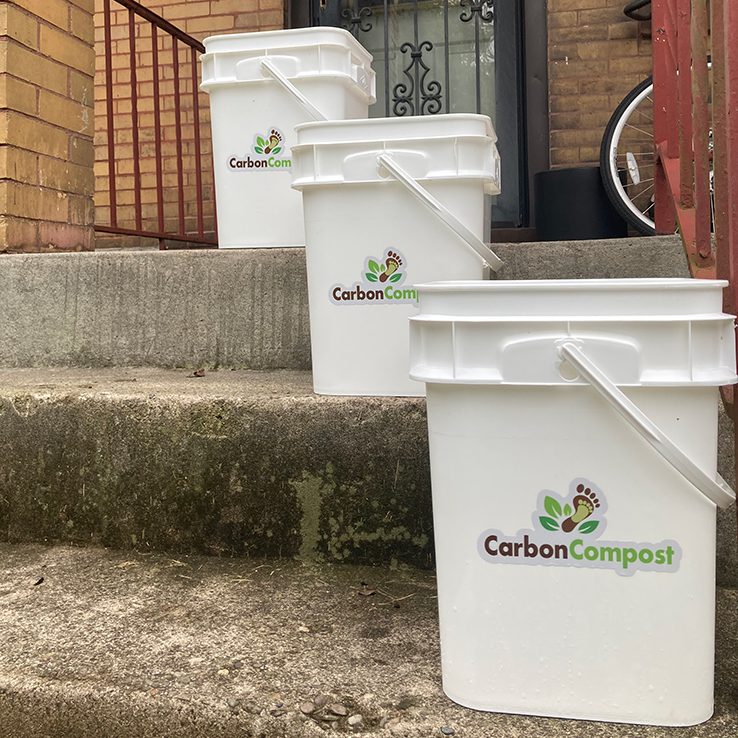 Carbon Compost buckets lined up ascending on front porch steps