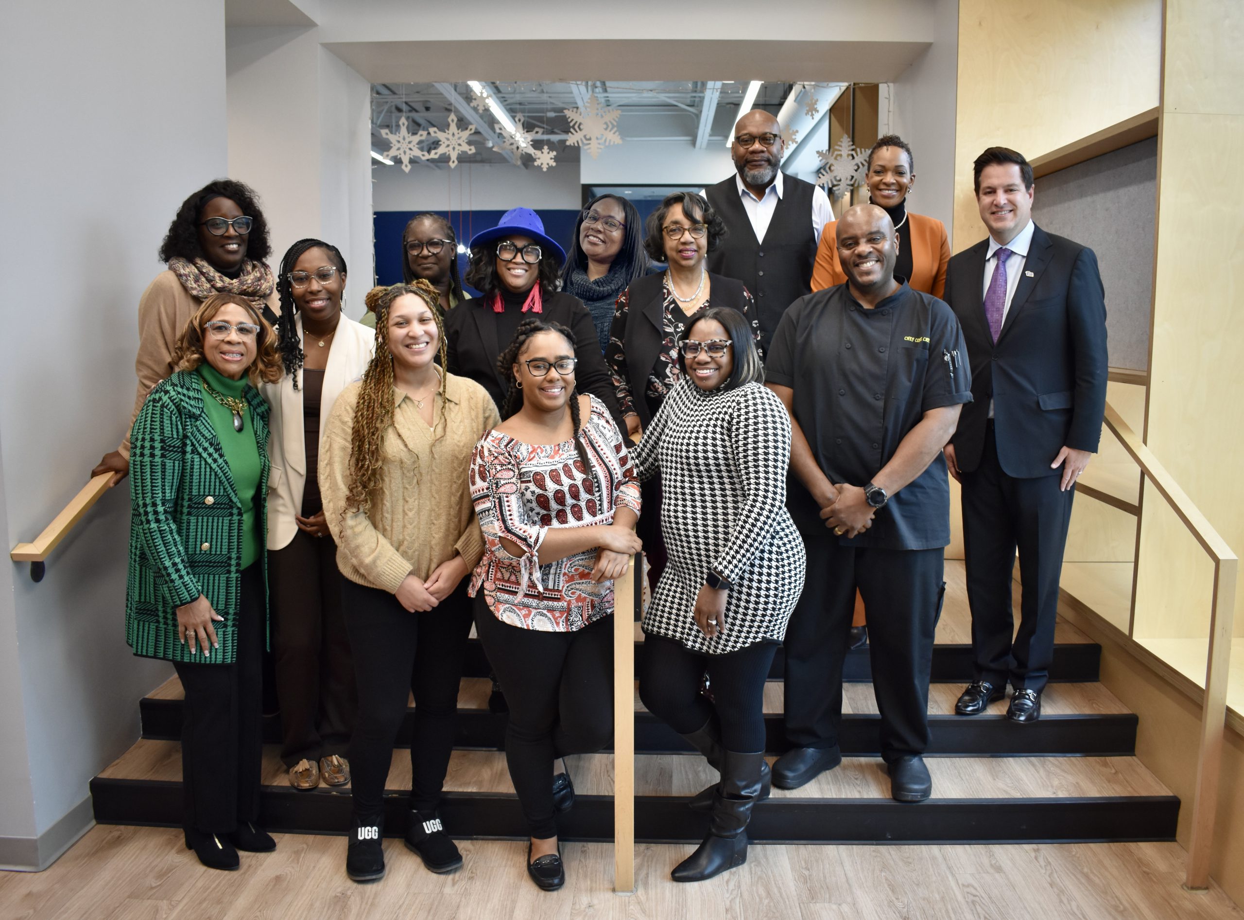 Group of graduates from the IEE's Community Power to Prosper program standing in three rows on a small set of steps